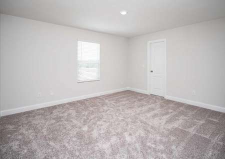 Carpeted spare room in the Kiawah floor plan with a closed closet door and a single hung window covered by blinds.
