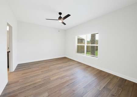 Master bedroom with ceiling fan and plank flooring
