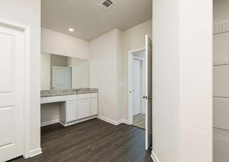 The master bathroom is spacious with a large vanity and linen closet
