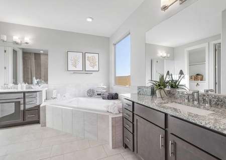 Mead master bathroom with two separate granite vanities, custom size bathtub, and ceramic tile floors