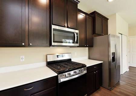 The Northwest Chelan side view of the kitchen shows white quartz countertop and dark brown cabinets.