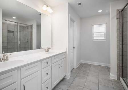 Fripp master bath with tile floors, walk-in shower, and dual sink vanity with large mirror