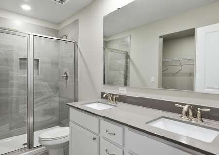 Master bathroom with dual sink vanity and a step in shower