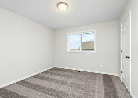 Photo of a bedroom with carpet, a closet and window.