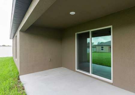 Shaded back patio with sliding doors for plenty of entertainment space. 