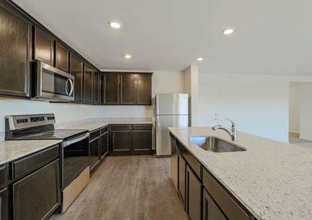 Incredible designer kitchen with stainless steel appliances, granite countertops, espresso cabinets and a kitchen island with an undermount sink.