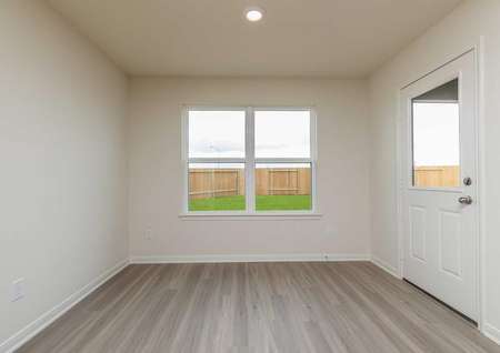 Blanco dining area with ceramic wood-like flooring, large backyard facing window, and white backyard door with window