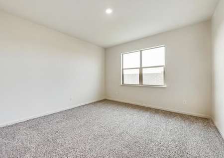 The master bedroom has brown carpet and light walls.
