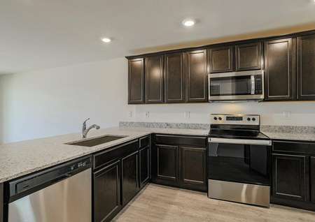 Incredible chef-ready kitchen filled with stainless steel appliances, sprawling wrap-around granite countertops and an undermount sink.