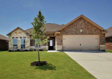 One-story Hendrie plan by LGI Homes with brick and stone exterior, glass front door, landscaped front yard.
