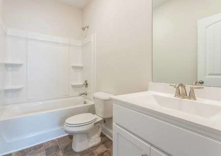Alexander guest bath with white fixtures, large vanity, and shower/bathtub unit