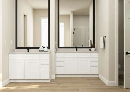 Rendering of the large master bath in the
  Primrose plan showcasing the two separate vanities with white cabinets and
  black fixtures.