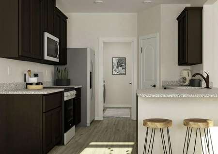 Rendering showing the kitchen with
  granite counters, dark brown cabinetry and stainless steel appliances. Three
  barstools are at the counter and the laundry room is visible through an open
  doorway.