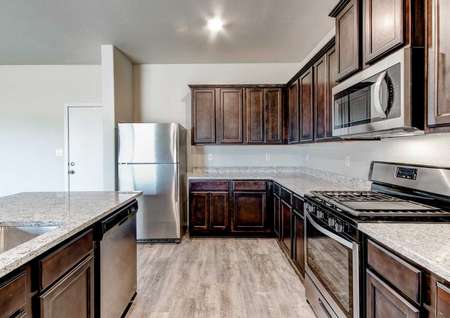 Snowflake kitchen with stainless steel applianecs, brown cabinetry and granite countetops