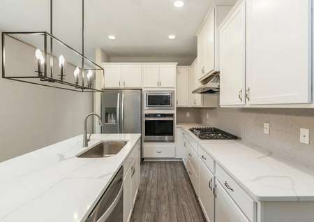 Show-stopping kitchen featuring beautiful quartz countertops, white cabinets and modern appliances.