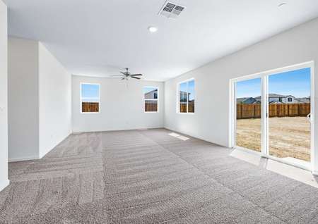 Spacious family room with carpet and ceiling fan