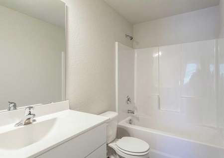 Alexander bathroom with shower/bath combo, toilet, and white vanity