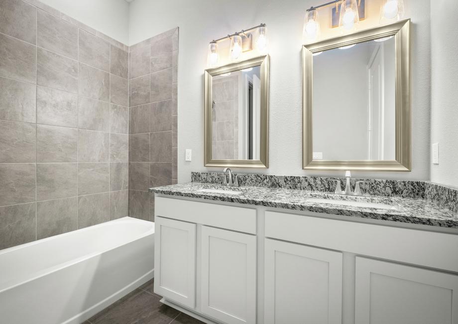 Secondary bathroom with mirrors and a large vanity.