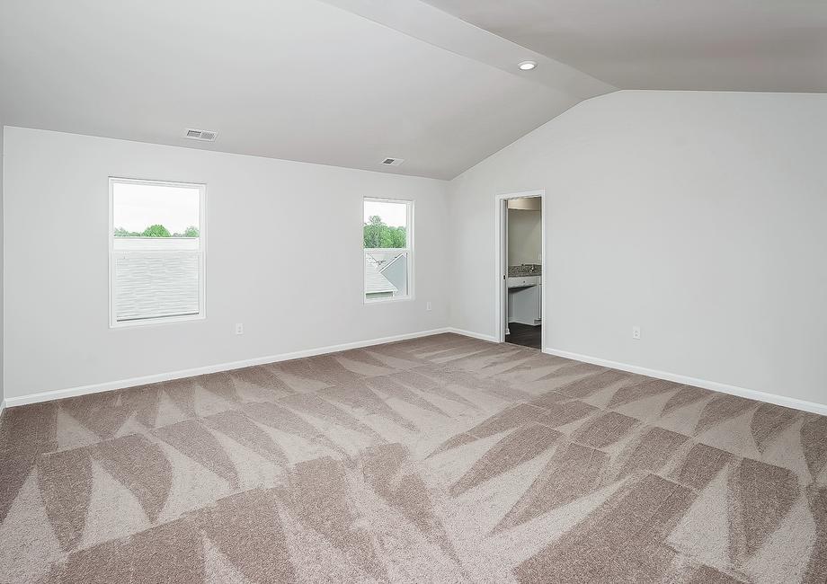 Master bedroom with two windows and carpet.