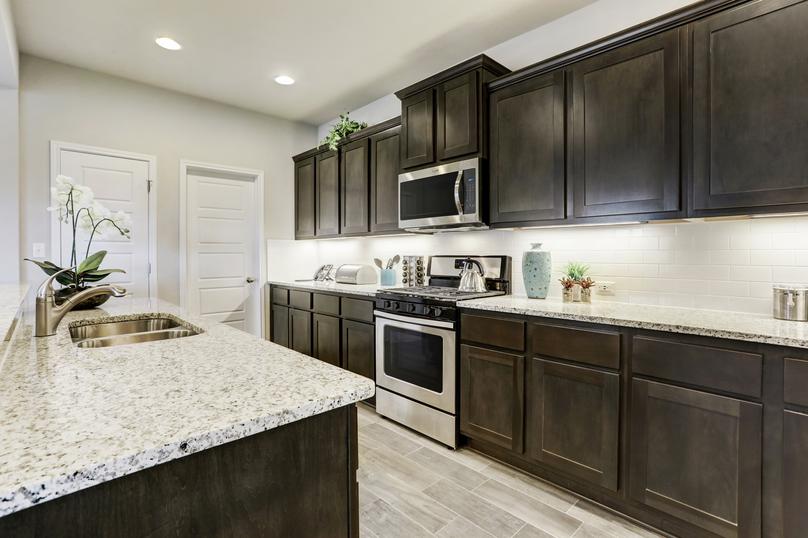 Kitchen with large island, stainless steel appliances and undermount cabinet lighting.