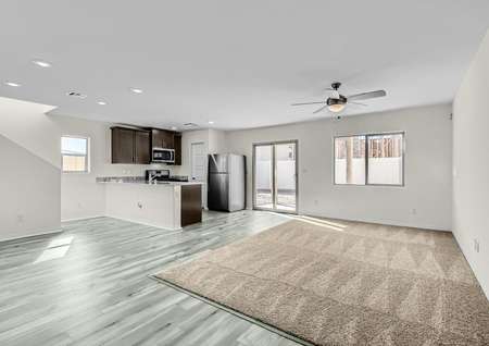 Open family room with an adjacent kitchen and covered back patio. 