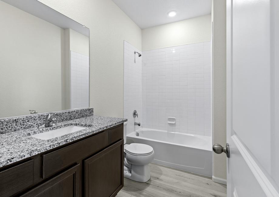 Guest bathroom with a dual shower and bath tub and a single-sink vanity.