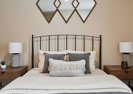 Bed with nightstands on either side and wall decor above.
