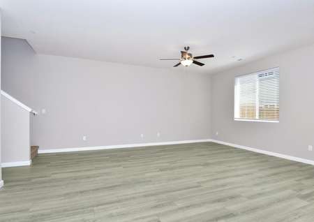Spacious family room with plank flooring and a ceiling fan