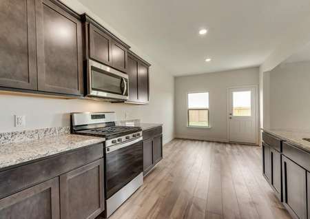 The kitchen is open to the dining area and features stainless steel appliances and a gas stove.