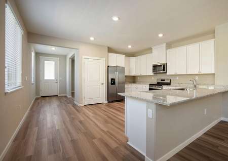 The kitchen is open to the foyer in this home.