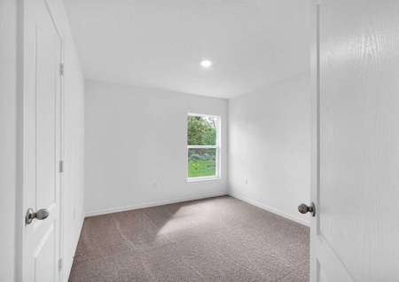 The entrance of a guest bedroom, its spacious closet and a window.