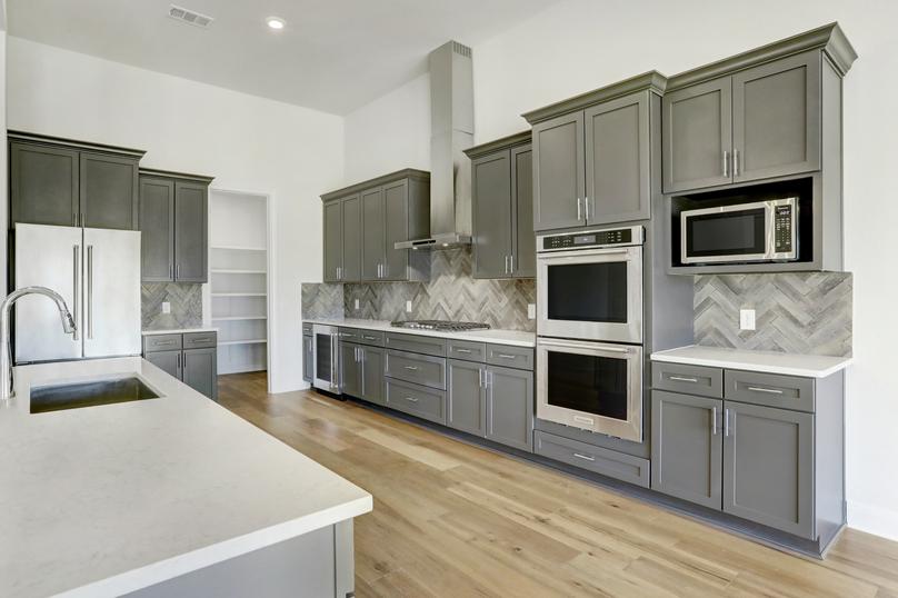 The kitchen offers beautiful wood cabinetry, quartz countertops and stainless steel appliances.