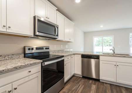 Kitchen with white cabinetry and stainless steel appliances. 