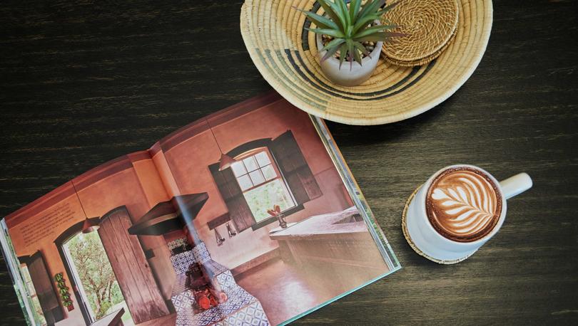 Stock photo detail shot of a wooden table with a cup of coffee and a magazine.