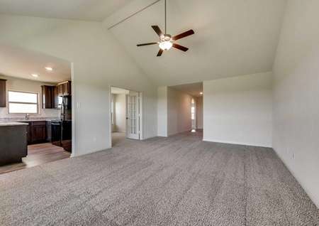 Sabine family room with carpeted floor, vaulted ceiling, and kitchen access