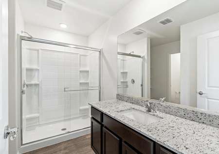 Master bathroom with a large walk-in shower and a vanity with granite countertops.