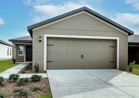 One-story home with a two-car garage, covered entryway and front yard landscaping.