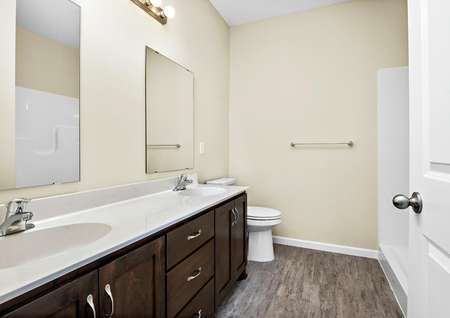 Photo of the primary bathroom with a dual-sink vanity, two mirrors and a supersize step-in shower.