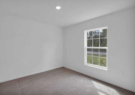 Spacious guest bedroom with a large window that lets in plenty of natural light.