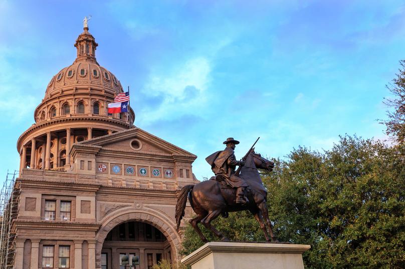 Austin, Texas State Capitol building showing the Texas Rangers statue, the custom stone architecture, and dome-shaped roof