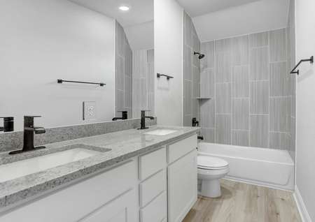 Guest bathroom with dual shower and tub, white cabinets, and granite countertops.