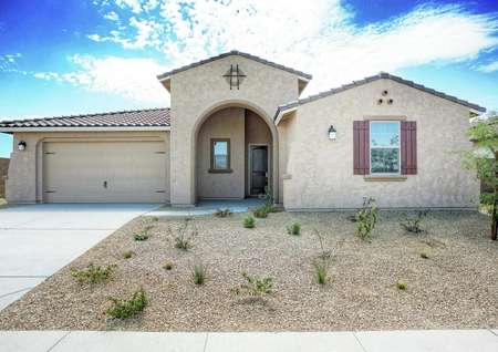 Bartlett finished house street view with desert landscaping, arched entryway, and beige stucco finish