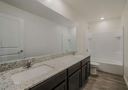 Gorgeous bathroom with dual sink vanity, granite countertops and a dual tub and shower.