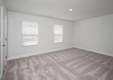 Spare bedroom with an overhead light fixture, white walls and light brown carpet in the Kiawah floor plan.