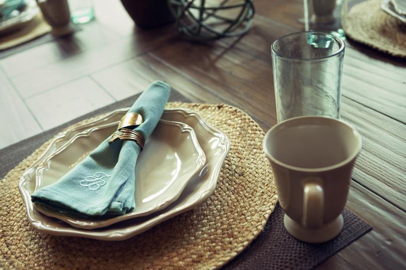 Dining table detail with coffee cup, plates and napkin.