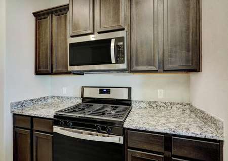 This kitchen comes complete with a full suite of stainless steel appliances and granite countertops.
