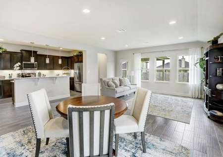Open concept floor plan, fully furnished with couch, dining table and chairs.