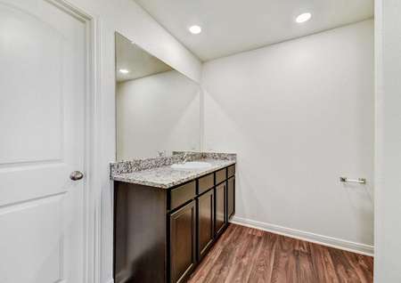 Medina bathroom with granite vanity, brown cabinets, and recessed lights