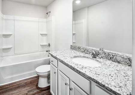 Secondary bathroom with a large granite vanity.