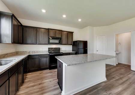 Jaguar kitchen with recessed lights, dark wood cabinets, and granite countertops
